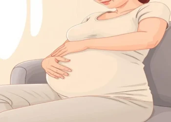 Pregnant woman experiencing tingling hands, massaging her wrist for relief from pregnancy-related discomfort
